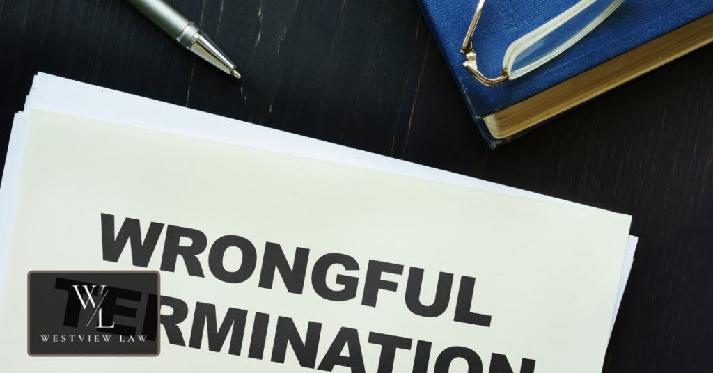 A printed wrongful termination document on a desk beside a pen, eyeglasses, and a law book, representing the case factors reviewed when calculating a settlement.